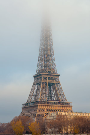 landscape with eiffel tower and fog in Paris, France in the evening.