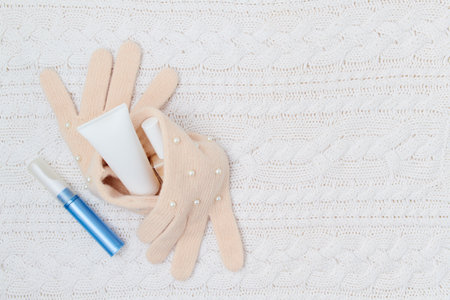 winter flat lay with medical mask and mandarins on white knitted background.の写真素材