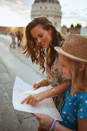 happy modern family with map near Pisa Cathedral.の写真素材