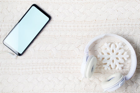 winter flat lay with clock hands, snowflakes, mandarins, sleds and skis on white knitted background.の写真素材