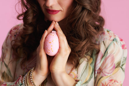 Closeup on female with easter egg praying isolated on pink.