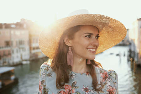 happy young traveller woman in floral dress with hat on Accademia bridge in Venice, Italy.の写真素材