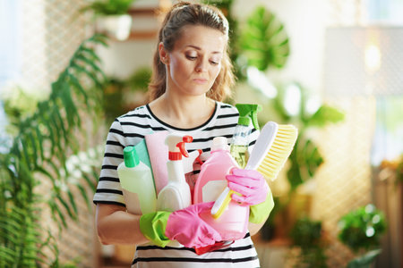 Closeup on woman with mop doing housekeeping at home in sunny day.の写真素材