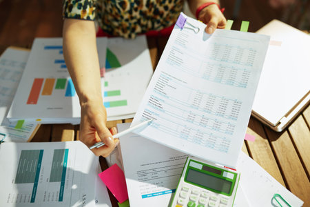 Tax time. Closeup on modern middle aged bookkeeper woman working with documents in the office.