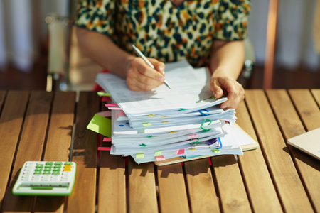 Tax time. Closeup on modern middle aged bookkeeper woman working with documents in the office.