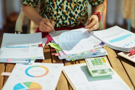 Tax time. Closeup on modern middle aged bookkeeper woman working with documents in the office.の写真素材