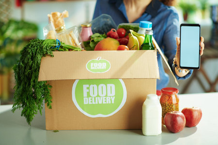 Food delivery. happy modern female with food box in the kitchen.