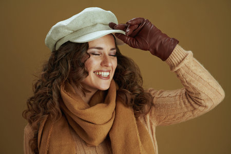 Hello autumn. Closeup on middle aged woman with book and leather gloves against bronze background.