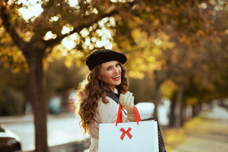 Hello autumn. dreamy trendy woman in beige trench coat with autumn yellow leaves at Old Town Square in Prague.の写真素材