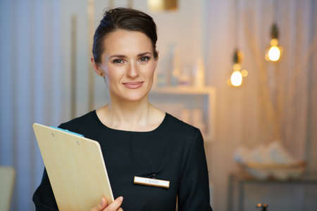 tired middle aged woman employee in modern beauty salon having neck pain.の写真素材