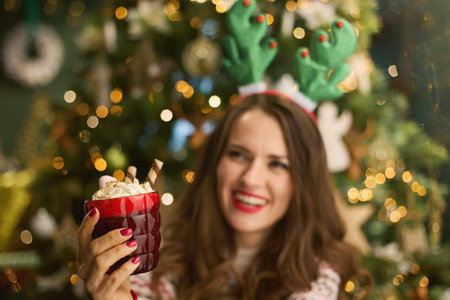 Christmas time. Closeup on happy 40 years old housewife with Christmas cookie in traditional...