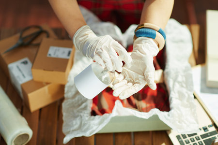 Closeup on small business owner woman with ffp2 mask, open after covid sign and disinfectant in the...