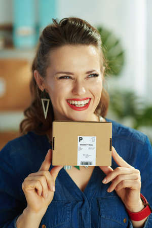 Closeup on small business owner woman with ffp2 mask, open after covid sign and disinfectant in the office.の写真素材