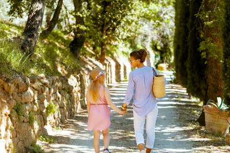 Travel in Italy. Seen from behind stylish woman with map and straw bag enjoying promenade in Tuscany, Italy.の写真素材