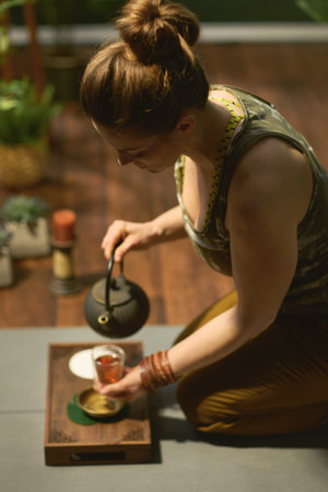 modern woman with smartphone listening to the music with headphones in the modern green house.の写真素材