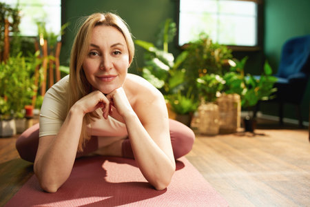 Portrait of modern woman in the modern green living room meditating.