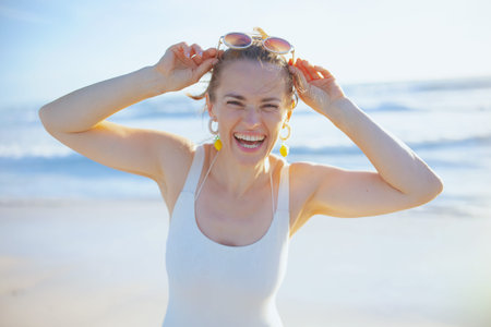 Portrait of smiling elegant 40 years old woman in white swimwear at the beach having fun time.の写真素材