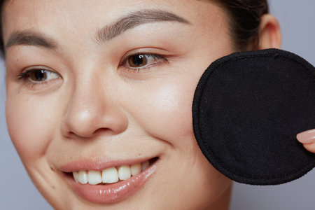 modern asian woman with black cotton pad against blue background.の写真素材