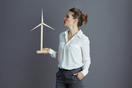 happy elegant middle aged business woman in white blouse with windmill isolated on grey.の写真素材