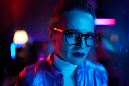 Neon metaverse futuristic concept. Portrait of modern business woman in glasses in modern office.の写真素材