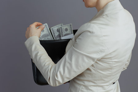 Closeup on middle aged small business owner woman in a light business suit with briefcase and...