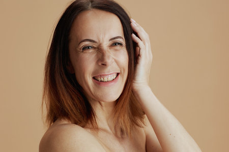 Portrait of modern middle aged woman with short hair isolated on beige background.の写真素材