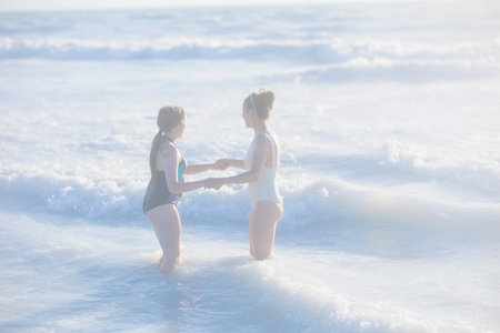 modern mother and teenage daughter at the beach in swimwear.の写真素材