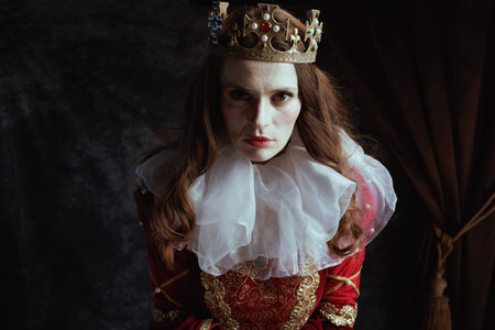 scary medieval queen in red dress with white collar and crown on dark gray background.