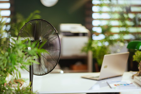 Summer time. metal fan in modern green office.の写真素材