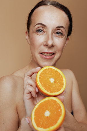 modern female with orange against beige background.の写真素材