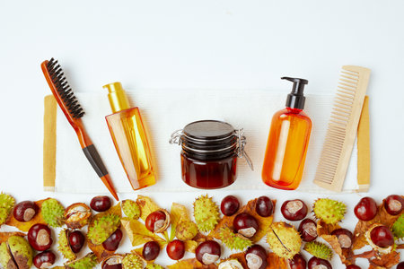 autumn background with autumn leaves, chestnut and hair cosmetics.の写真素材