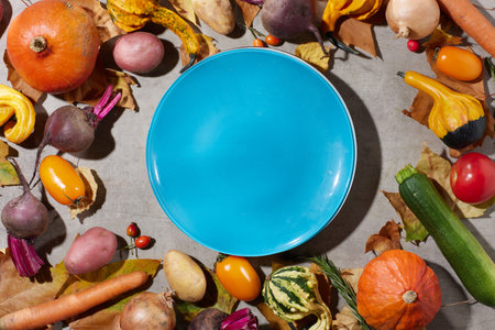 autumn flat lay on a gray background with pumpkins, beetroot, autumn leaves, autumn leaf, plate and autumn vegetables.の写真素材