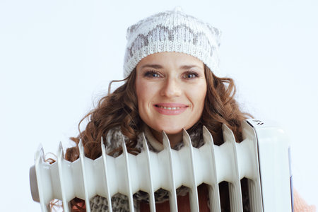 Hello winter. smiling trendy female in sweater, mittens, hat and scarf isolated on white background...