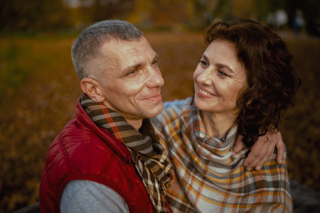 Hello autumn. smiling romantic boyfriend and girlfriend in the park having fun time.の写真素材