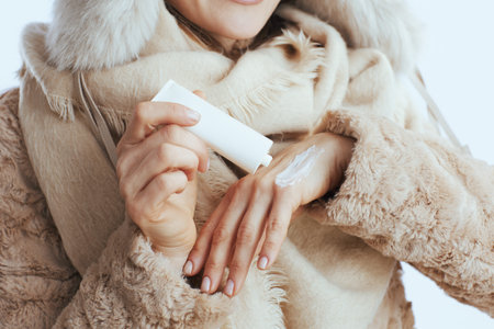 Closeup on woman against white background with hand cream.の写真素材