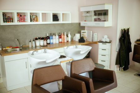modern beauty salon with chairs, bottles of hair care products and salon backwash unit.の写真素材
