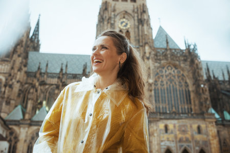 happy young traveler woman in yellow blouse and raincoat in Prague Czech Republic sightseeing.の写真素材