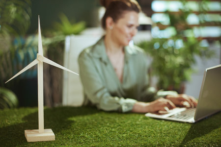 Eco trends. Closeup on smiling small business owner woman in green blouse in green office with...