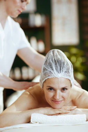Healthcare time. medical massage therapist in massage cabinet with relaxed client massaging clients back.の写真素材