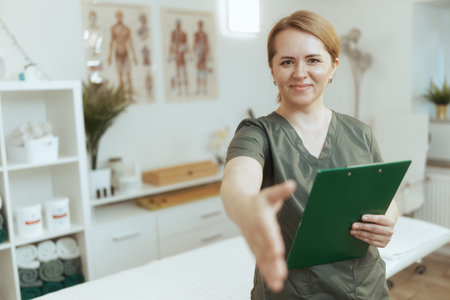 Healthcare time. happy female massage therapist in massage cabinet with clipboard.