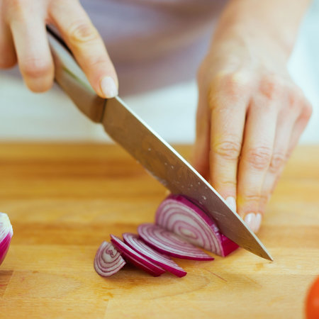 Closeup on woman cutting red onionの写真素材