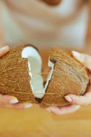 Closeup on young woman opening coconut