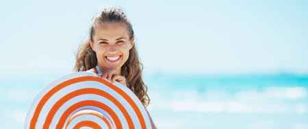 happy young woman in swimsuit with beach hat