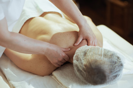 Healthcare time. massage therapist in massage cabinet massaging clients neck on massage table.の写真素材
