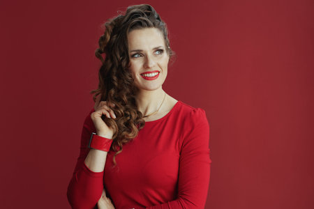 Happy Valentine. stylish middle aged woman with long wavy hair in red dress and beret against red background.の写真素材
