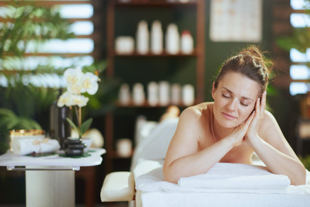 Healthcare time. relaxed modern 40 years old woman in massage cabinet laying on massage table.の写真素材