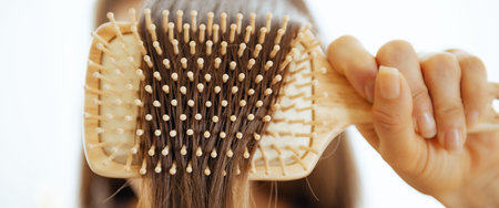 Closeup on young woman combing hairの写真素材