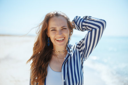 Portrait of happy elegant woman on the ocean coast having fun time.の写真素材