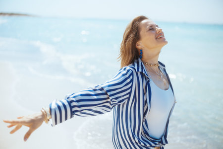 smiling modern female on the beach rejoicing.の写真素材