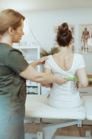 Healthcare time. pensive massage therapist woman in massage cabinet with client doing checkup.の写真素材